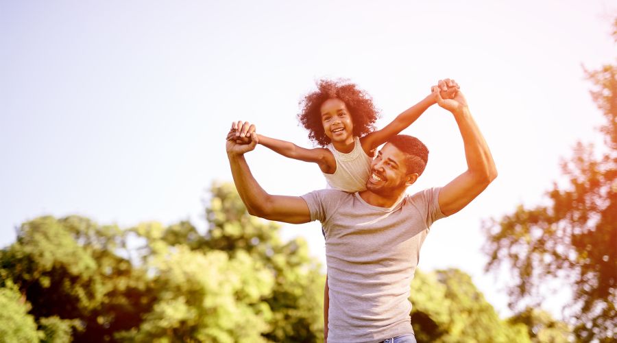 child on dads shoulders