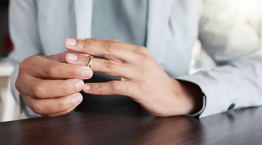 a person about to take off a wedding ring