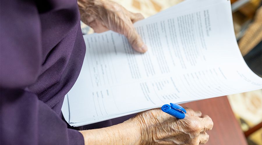 old woman signing documents