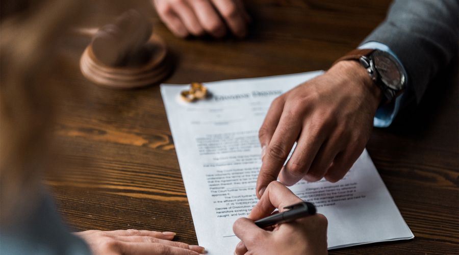 couple signing divorce papers with an attorney