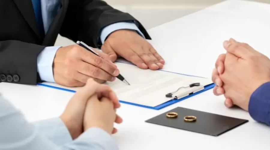 couple sitting at a table with rings on top next to paperwork