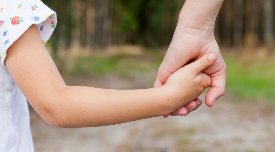 mother holding childs hand